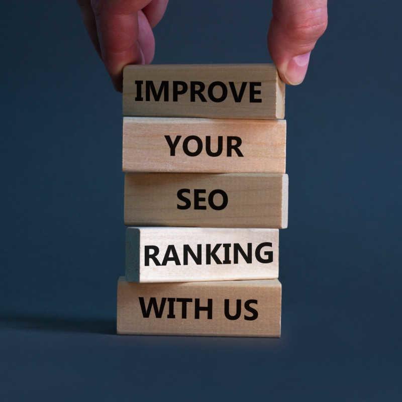 Improve Your Seo Ranking With Us Symbol. Wooden Blocks With Words Improve Your Seo Ranking With Us. Businessman Hand. Beautiful Grey Background, Copy Space. Business, Improve Seo Ranking Concept.